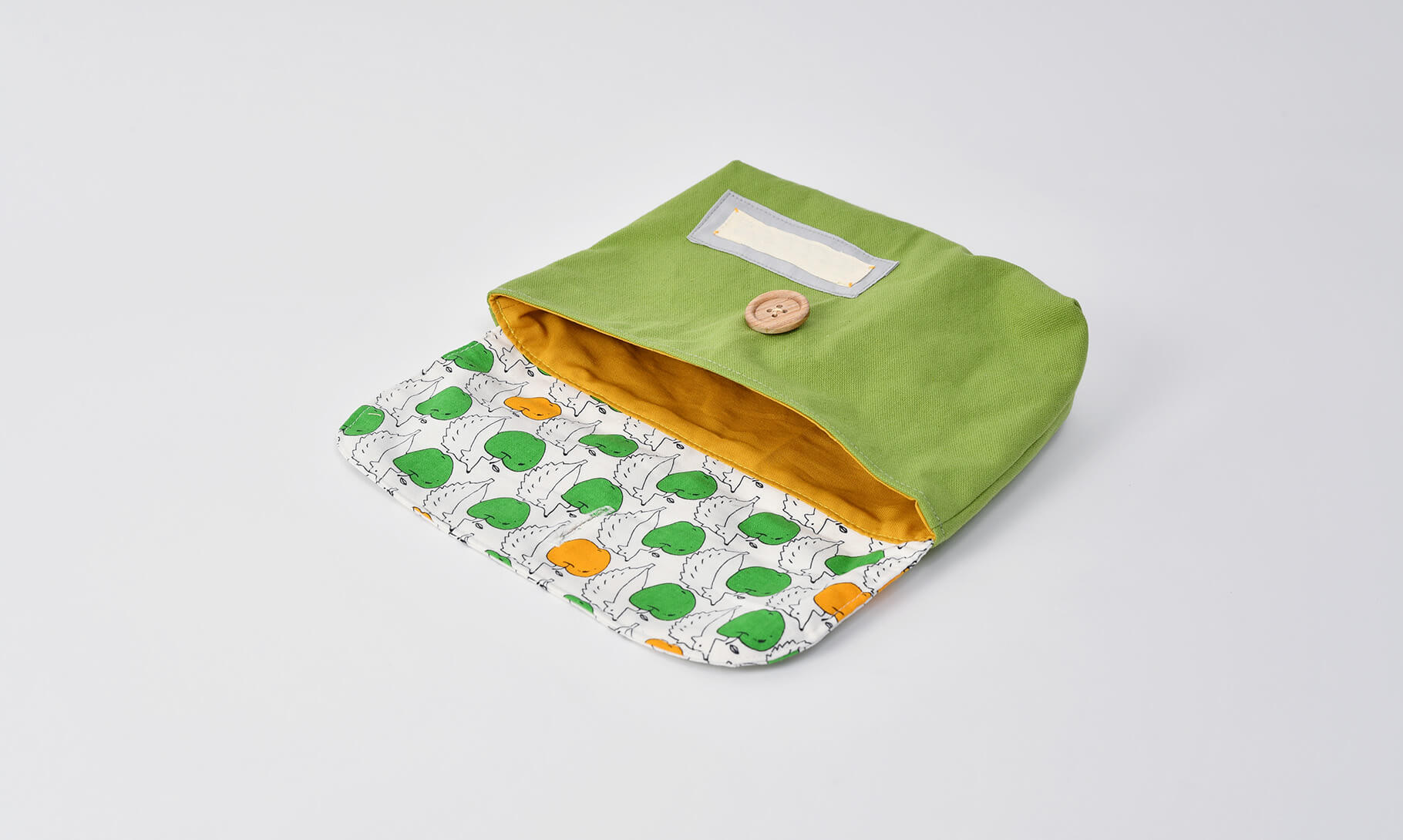 封筒型弁当袋(リンゴとハリネズミ、帆布グリーン )裏地マスタードと木のボタン