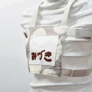 子供用ゼッケン（きなりの大きなドットとダークベージュ）ストラップの色きなり、斜めから