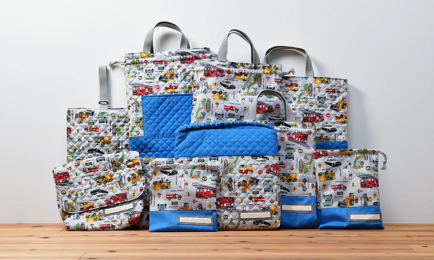 持ち込みの入園グッズセット(持ち込み生地 はたらく車総柄、無地青）（上履き入れ、封筒型弁当袋、他、計10点)