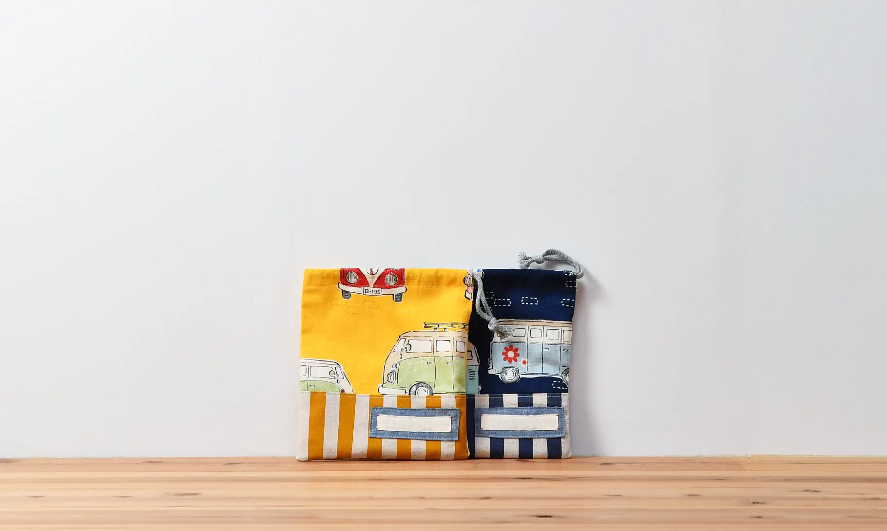 コップ袋（レトロバスイエロー、ストライプイエロー）と、コップ袋（レトロバスネイビー、ストライプダークネイビー）、ひもの色グレー